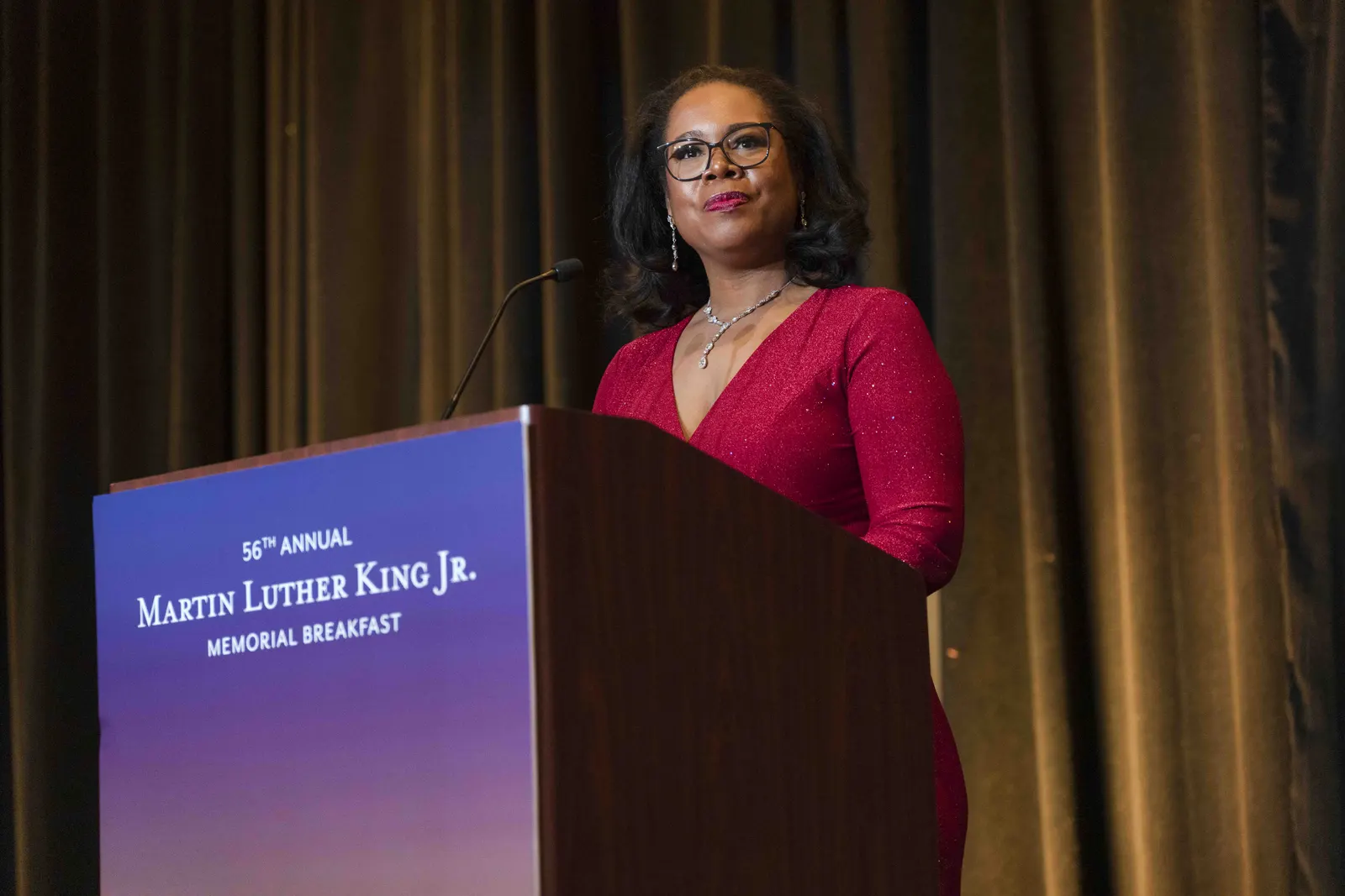 A speaker delivering remarks from the podium at the MLK Memorial Breakfast